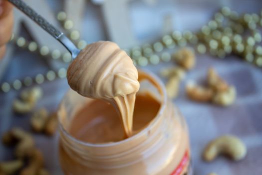 Creamy peanut butter and spoon on background.