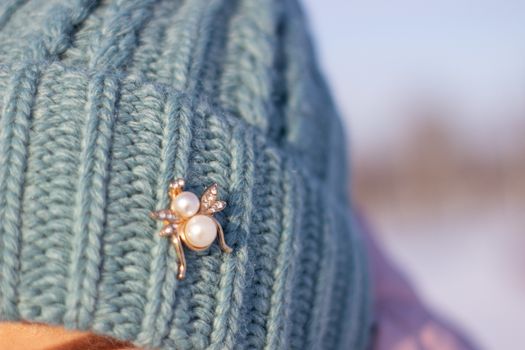 A woman in a knitted, turquoise winter hat.