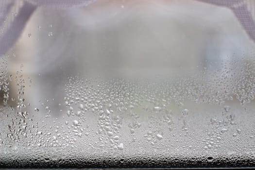 Close-up clear drops of water on window glass surface.