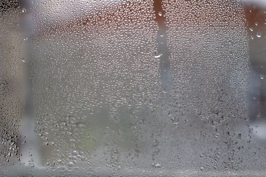 Close-up clear drops of water on window glass surface.