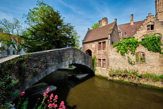 Famous tourist tourism spot for selfile old Bonifacius Bridge over Brugge canal and medieval houses with flowers in Bruges, Belgium