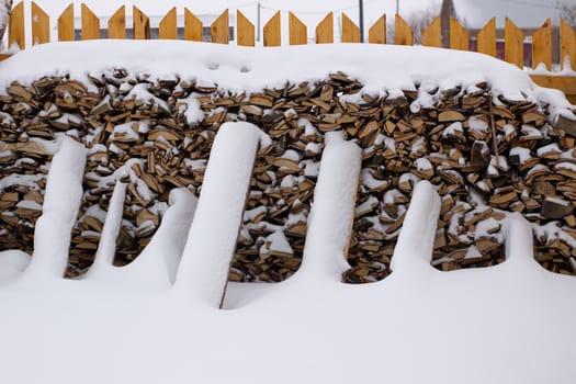 Firewood for the bath near the fence in winter. Birch firewood.