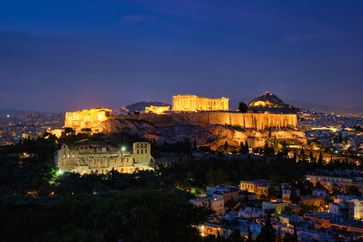 Famous greek tourist landmark - the iconic Parthenon Temple at the Acropolis of Athens as seen from Philopappos Hill in the evening blue hour, Athens, Greece
