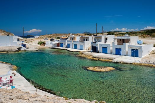 The beach of Agios Konstantinos with crystal clear turquoise water and traditional greek white houses. Milos island, Greece