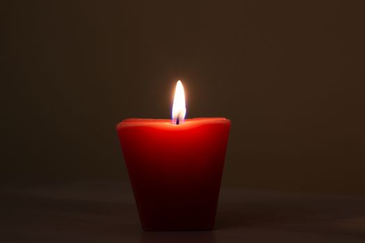 Closeup of burning candle isolated on black background.