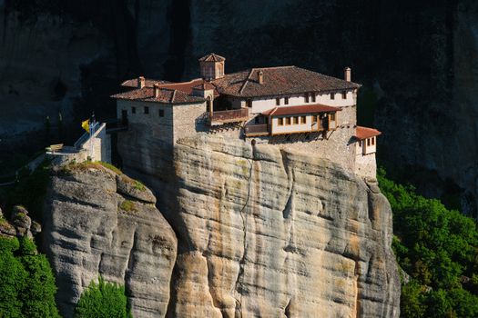 Monastery of Rousanou perched on a cliff in famous greek tourist destination Meteora in Greece on sunset with scenic landscape