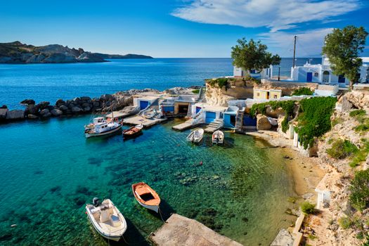 Typical Greece scenic island view - small harbor with fishing boats in crystal clear turquoise water, traditional white houses church. Mandrakia village, Milos island, Greece.