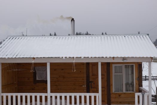 Wooden bath in winter in Siberia. Bath with veranda.