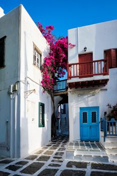 Picturesque scenic narrow streets with traditional whitewashed houses with blue doors windows of Mykonos Chora town in famous tourist attraction Mykonos island, Greece