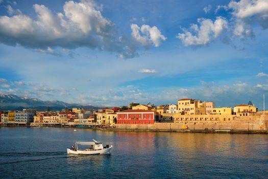 Fishing boat going to sea in picturesque old port of Chania is one of landmarks and tourist destinations of Crete island in the morning. Chania, Crete, Greece