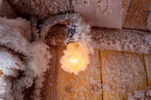 Snow crystals on a wooden wall and a light bulb