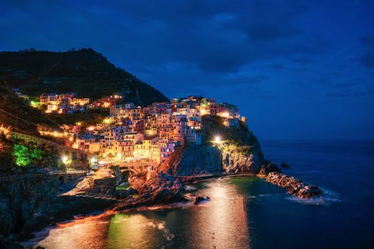 Manarola village popular european italian tourist destination in Cinque Terre National Park UNESCO World Heritage Site, Liguria, Italy illuminated in the evening