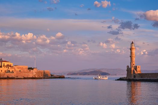 Fishing boat going to sea in picturesque old port of Chania is one of landmarks and tourist destinations of Crete island in the morning. Chania, Crete, Greece