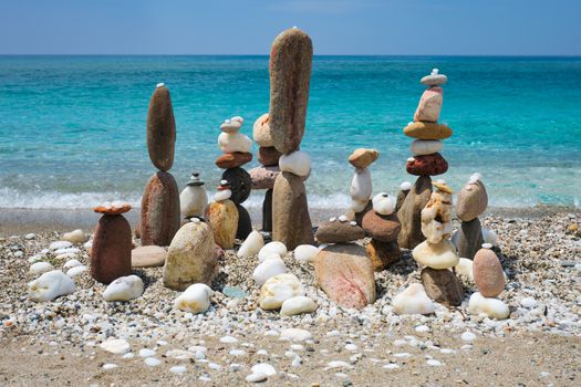 Concept of balance and harmony. Stones pebbles stacks on the beach coast of the blue sea in the nature. Meditative art of stone stacking.