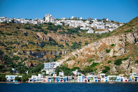 Klima and Plaka villages with whitewhashed traditional houses and orthodox church and windmills on Milos island, Greece