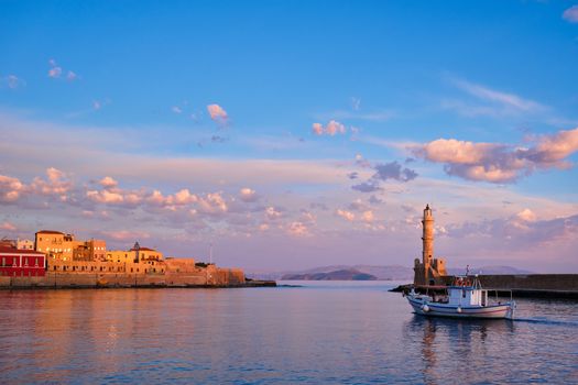 Fishing boat going to sea in picturesque old port of Chania is one of landmarks and tourist destinations of Crete island in the morning. Chania, Crete, Greece