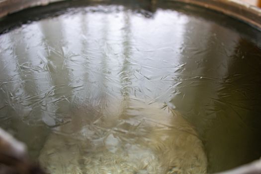 Bucket of water on the table in the cold. Close-up of an ice bucket on the background