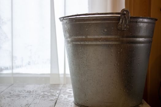 Bucket of water on the table in the cold. Close-up of an ice bucket on the background