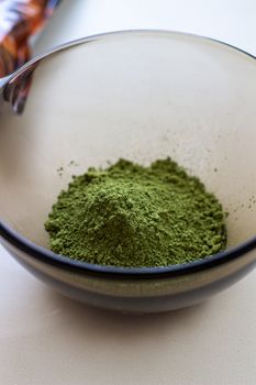 Mixing henna with a wooden spoon in a bowl for hair application of natural color like Indian henna mix