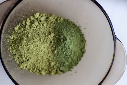 Mixing henna with a wooden spoon in a bowl for hair application of natural color like Indian henna mix