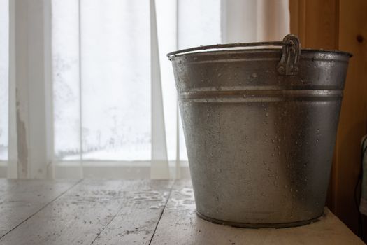 Bucket of water on the table in the cold. Close-up of an ice bucket on the background