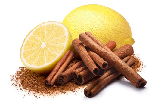 Whole and a half of lemon next to pile of cinnamon sticks and ground cinnamon. Clipping paths, shadow separated