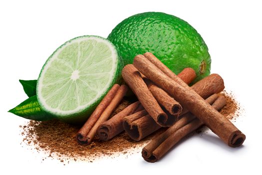 Whole and a half of lime with leaves next to pile of cinnamon sticks and ground cinnamon. Clipping paths, shadow separated