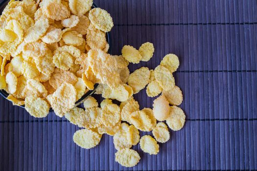 Bowl of cornflakes on bamboo napkin