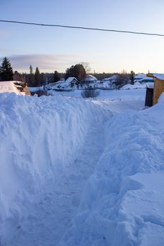 Wooden houses and fences covered with snow in Siberia, Russia