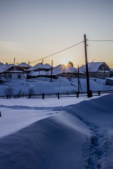 Wooden houses and fences covered with snow in Siberia, Russia