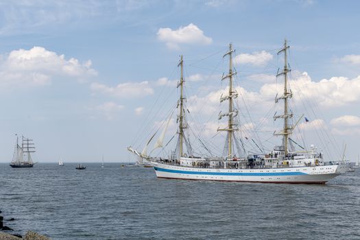 Antique tall ship, vessel leaving the harbor of The Hague, Scheveningen under a sunny and blue sky