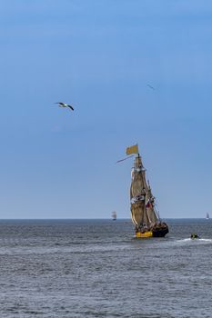 Antique tall ship, vessel leaving the harbor of The Hague, Scheveningen under a sunny and blue sky