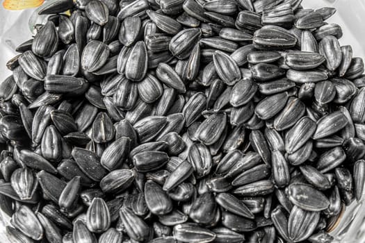 Black fried seeds in a plate close-up