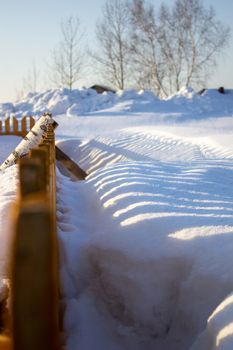 Wooden fence in the snow. Snow background.