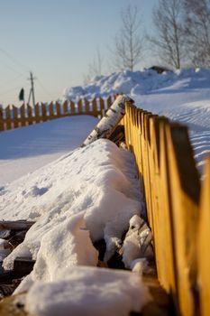 Wooden fence in the snow. Snow background.