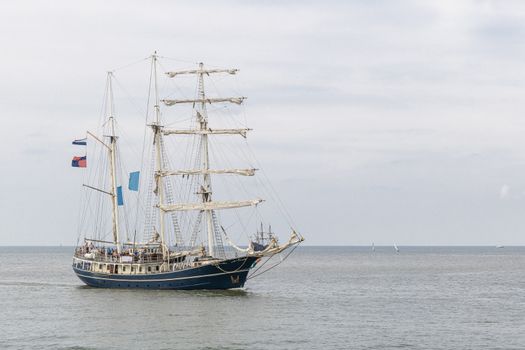 Antique tall ship, vessel entering the harbor of The Hague, Scheveningen under a sunny and blue sky