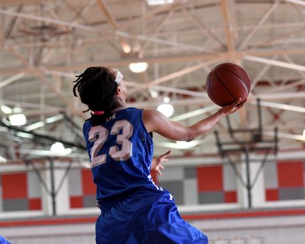 Young athletes making great basketball plays during a game. Slam Dunks and layups