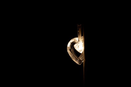 Heart-shaped light bulb in the dark.