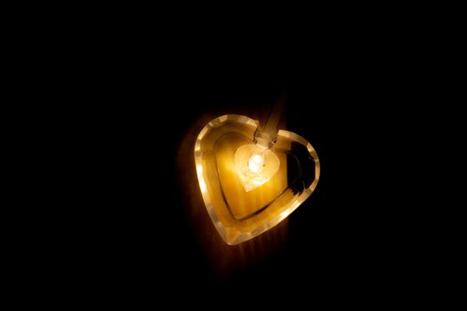 Heart-shaped light bulb in the dark.