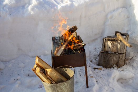 Barbecue with wood in winter on the street. Family holiday. Fry kebabs