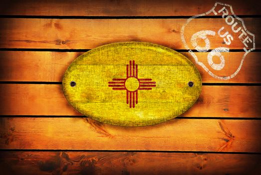 Brown wooden planks with the New Mexico flag and shield of Route 66.