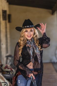 A gorgeous blonde model dressed as a cowgirl enjoying the outdoor weather