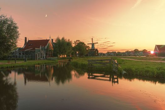 Typical Dutch rural landscape with windmill silhouettes at the early morning sunrise in Netherlands