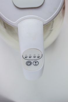The power and temperature button on the electric kettle is white.