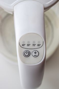 The power and temperature button on the electric kettle is white.