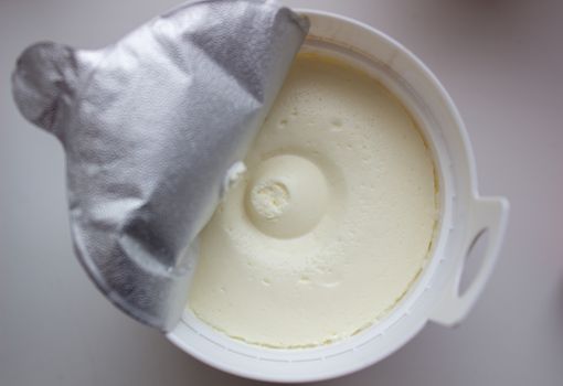 Cottage cheese in a container on a white background