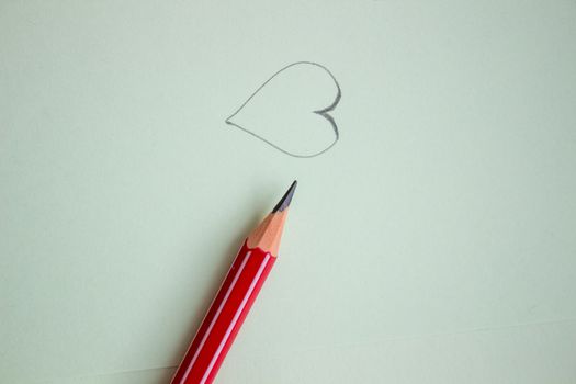 Heart drawn in pencil on a paper sheet, Close-up.