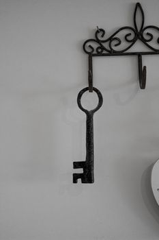 Keys hanging from hooks, on light wall background.