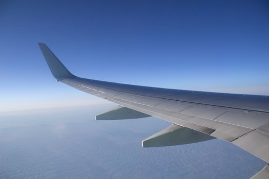 Airplane wing in the sky. View from a great height