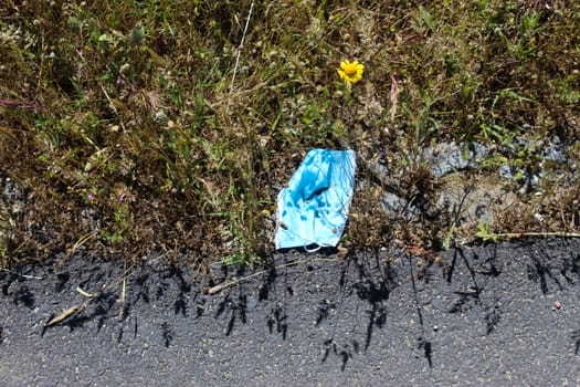 Discarded roadside mask, during Corona virus. Garbage, environmental pollution.